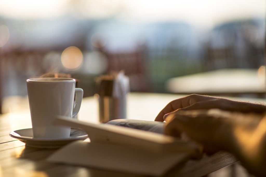 Young woman reading a book in a cafe